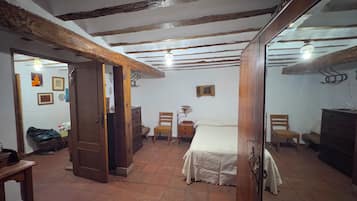 Una habitación con cama, muebles de madera y suelo de baldosas.