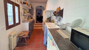 Una cocina con una isla central, horno empotrado y pileta.