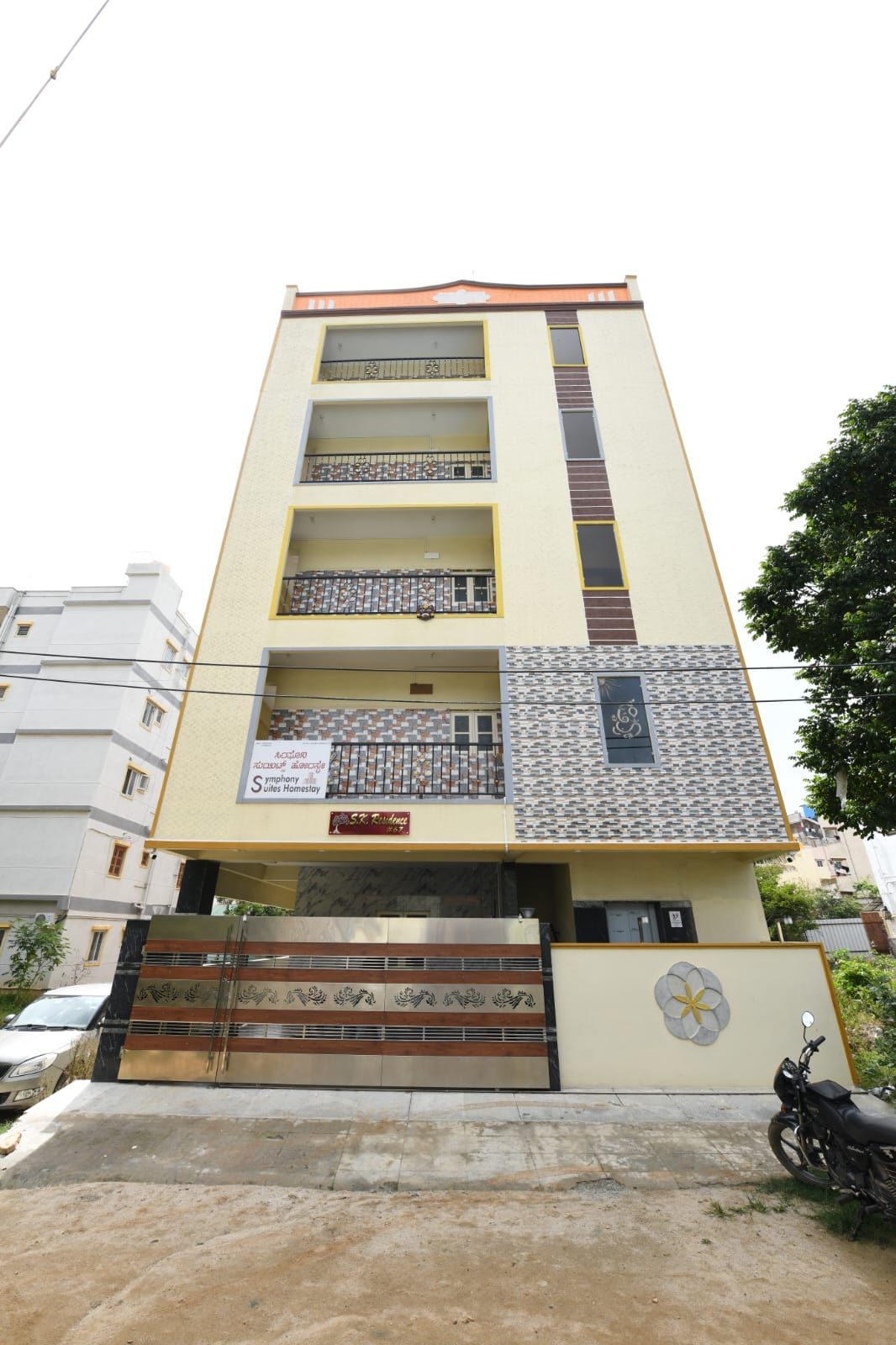 Un edificio de varios pisos con una fachada simétrica, balcones en cada nivel y una entrada con portones.