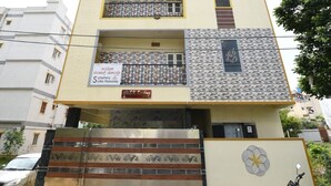 Un edificio de varios pisos con una fachada simétrica, balcones en cada nivel y una entrada con portones.