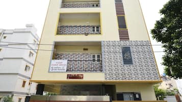 Un edificio de varios pisos con una fachada simétrica, balcones en cada nivel y una entrada con portones.