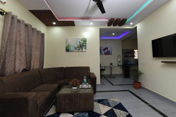 A modern living room with a sectional sofa, a coffee table, and artwork on the walls.
