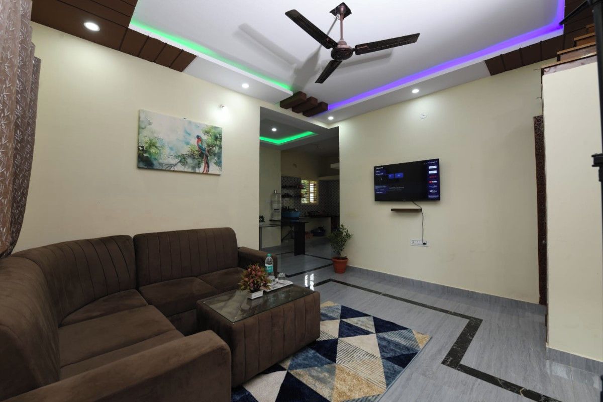A modern living room with a brown sofa, a glass coffee table, and a painting on the wall.