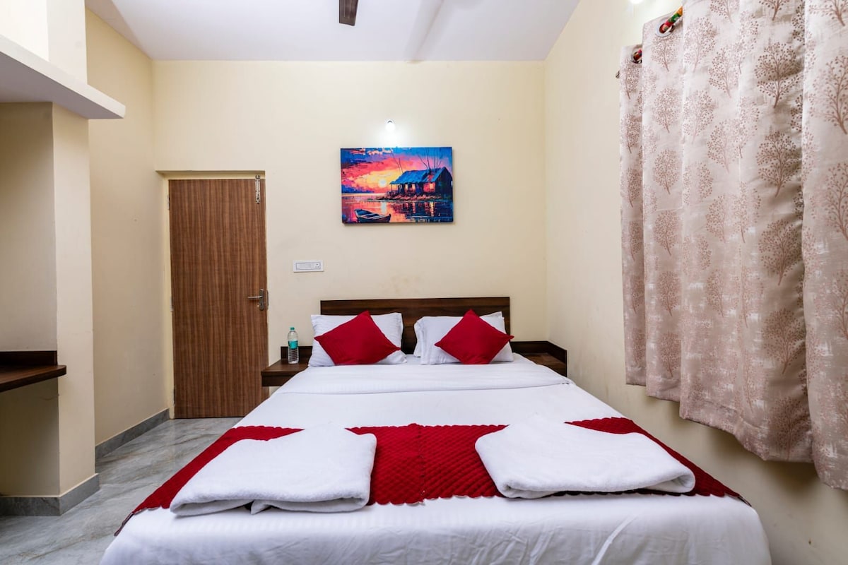 Una habitación de hotel con una cama, una mesita de noche, un cuadro en la pared y una cortina.