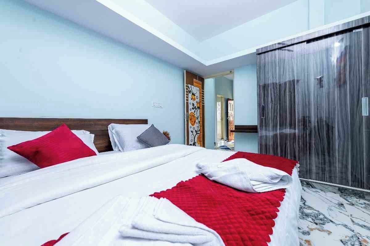 Una habitación de hotel con una cama, un armario y un espejo.