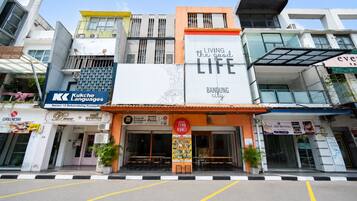 A multi-story commercial building with various storefronts, including a language school, a restaurant, and a moving company.
