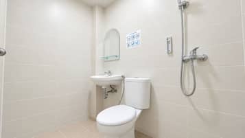 Un baño moderno con inodoro, lavamanos y ducha.