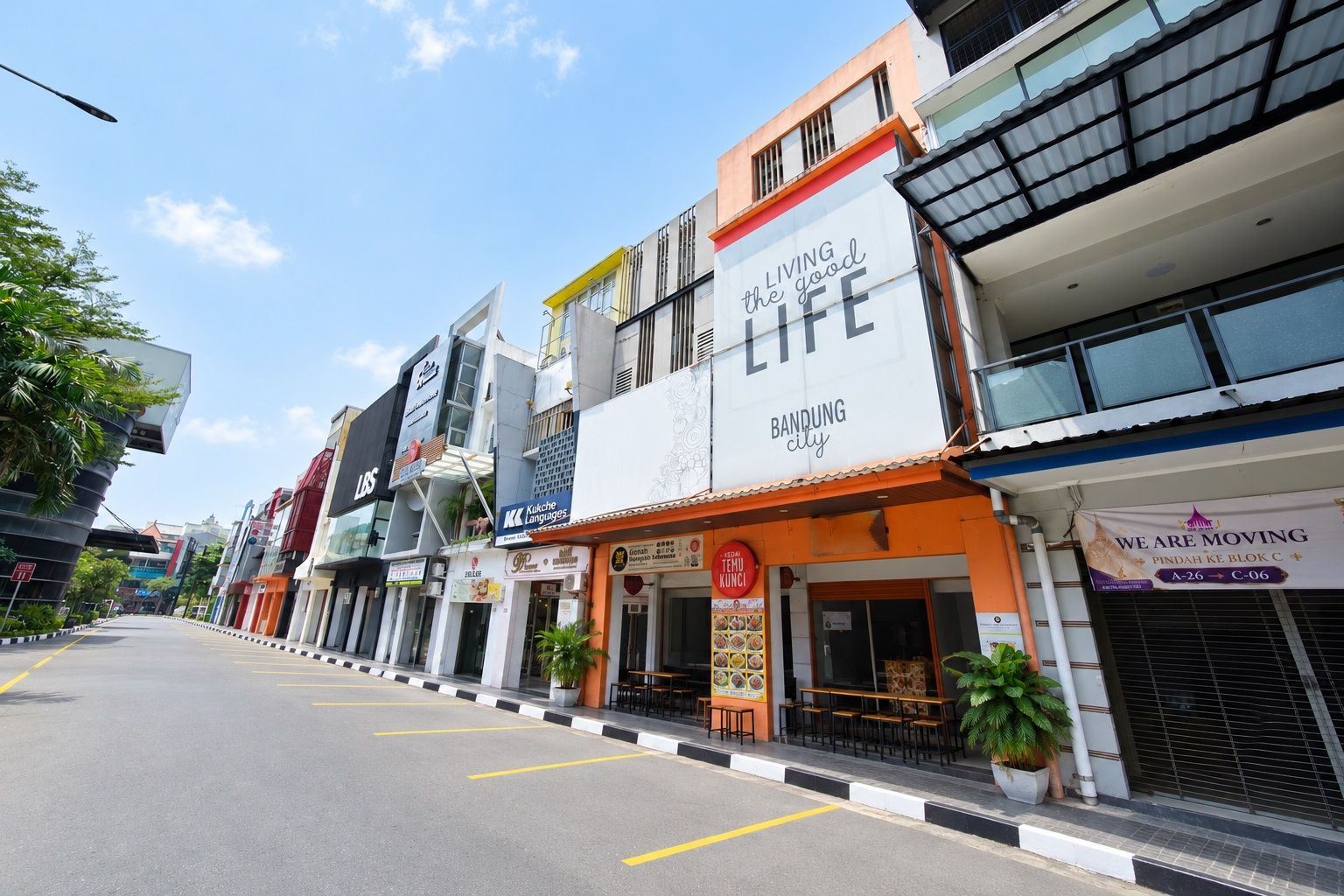 A street view with various commercial buildings, including a restaurant with outdoor seating.