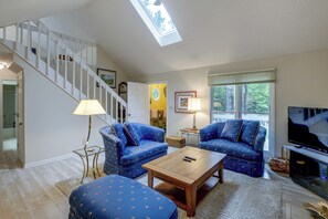 A living room with a staircase, two blue sofas, a wooden coffee table, and a television. - 2 Mi to Beech Mtn Resort Lifts: Family Home (Beech Mountain)