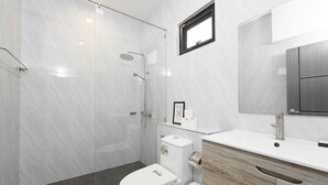 A modern bathroom with a glass-enclosed shower, a white toilet, and a wooden vanity with a mirror. - Elyana Haven | Luxury 3BR Private Pool Villa in Rawai, Phuket (Tambon Rawai)