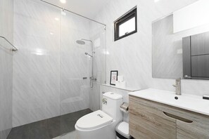 A modern bathroom with a glass-enclosed shower, a white toilet, and a wooden vanity with a mirror. - Elyana Haven | Luxury 3BR Private Pool Villa in Rawai, Phuket (Tambon Rawai)