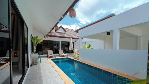 A modern outdoor pool area with a clear blue pool, lounge chairs, and a covered seating area. - Elyana Haven | Luxury 3BR Private Pool Villa in Rawai, Phuket (Tambon Rawai)