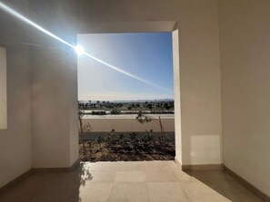 Una habitación con vistas a un paisaje, una ventana y una puerta que da al exterior.