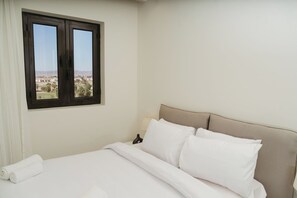 Ein Hotelzimmer mit Bett, Fenster mit Blick und einer Lampe.