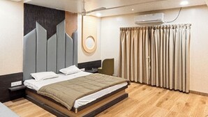 Un dormitorio moderno con una cama grande, un ventilador de techo y un equipo de aire acondicionado instalado en la pared.