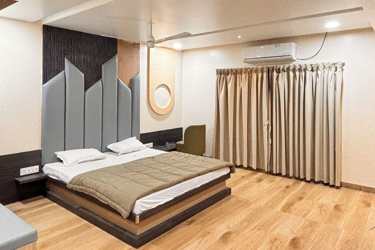 A modern bedroom with a large bed, a ceiling fan, and a wall-mounted air conditioning unit.