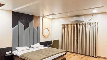 A modern bedroom with a large bed, a ceiling fan, and a wall-mounted air conditioning unit.