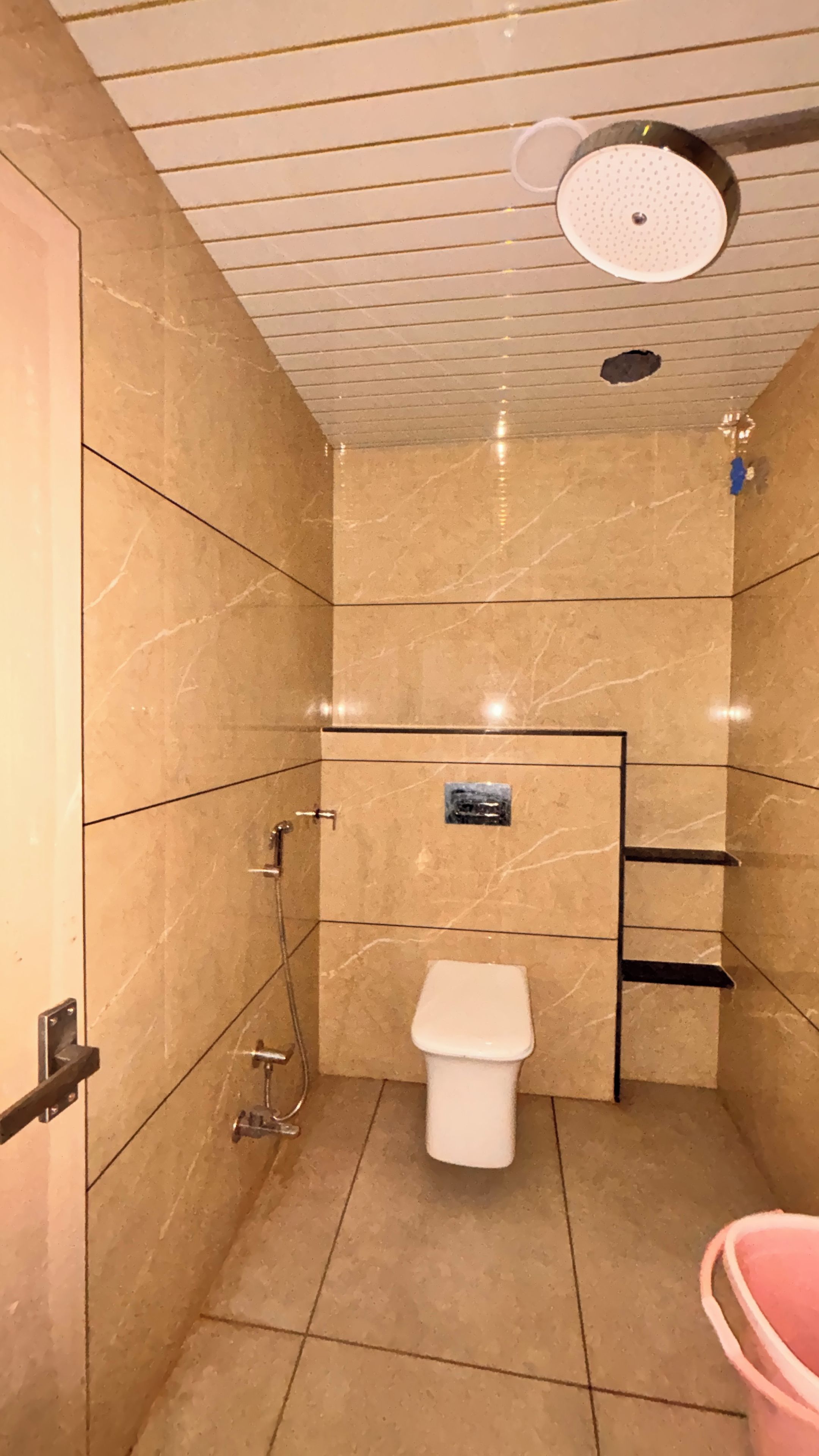 Ein kleines Badezimmer mit Fliesen, einer Toilette, einer Dusche und einem Waschbecken.