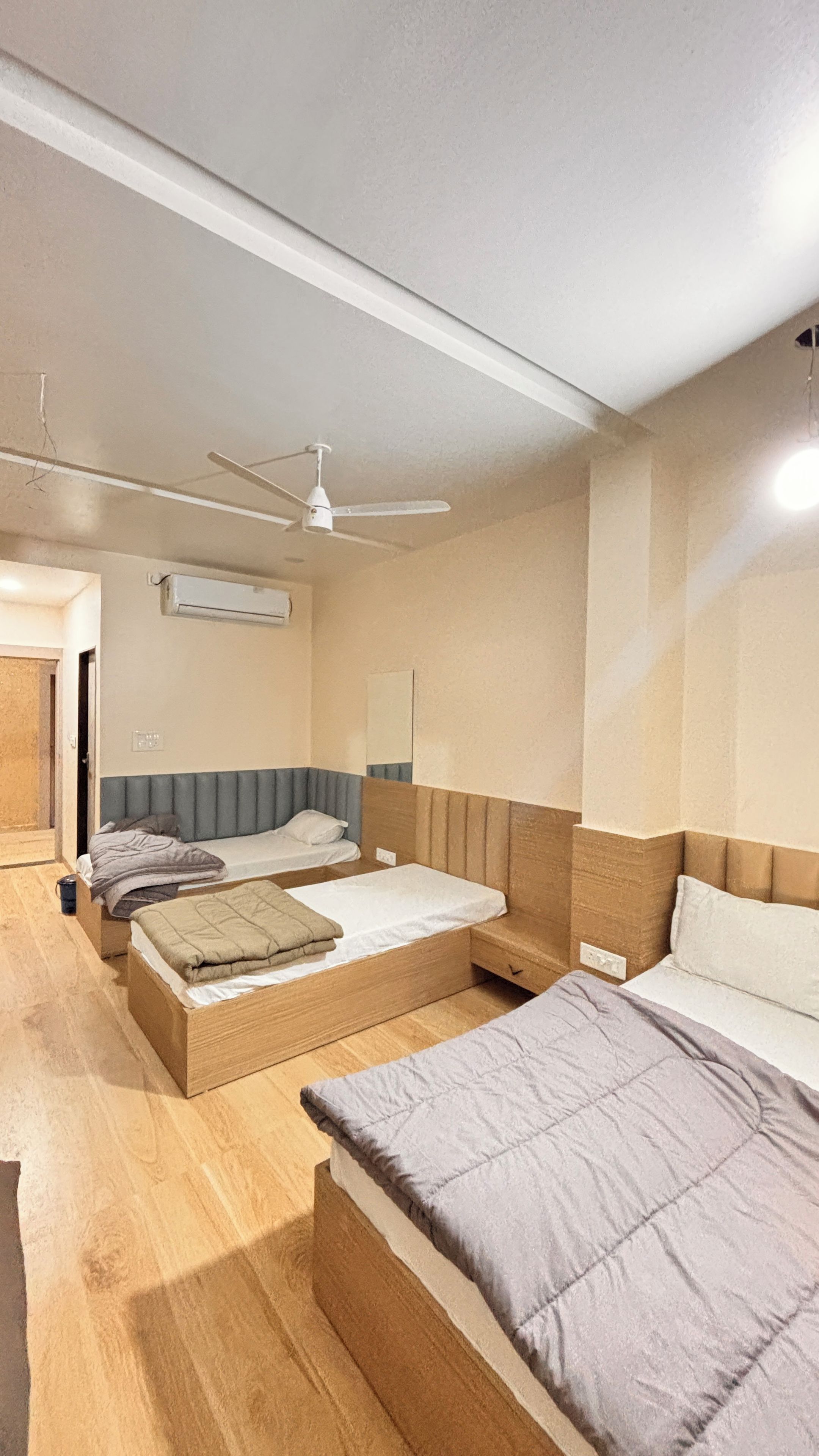 Habitación de hotel con dos camas, ventilador de techo y aire acondicionado.