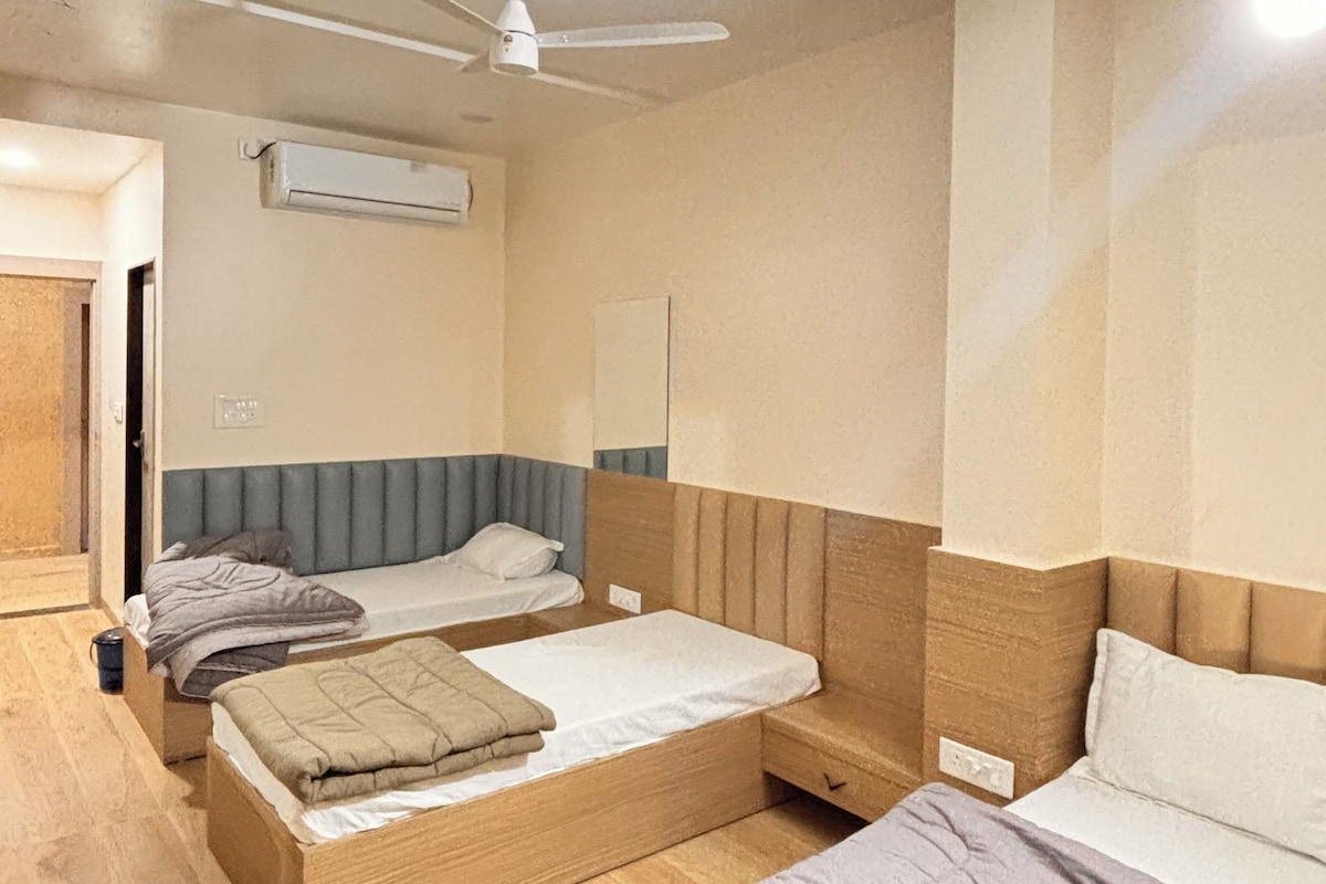 A hotel room with two beds, a ceiling fan, and an air conditioning unit.