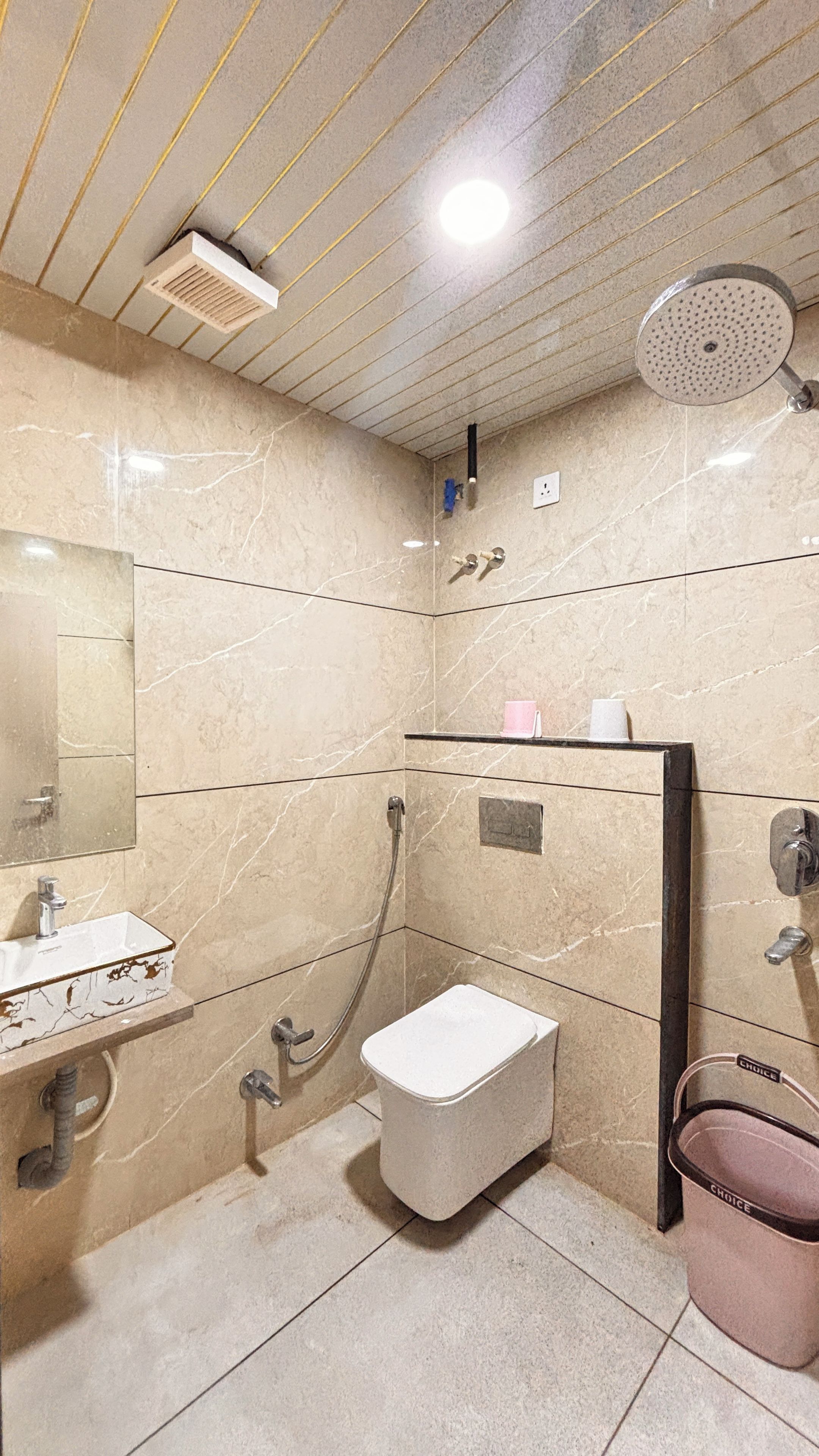 A bathroom with a sink, toilet, shower, and a mirror.