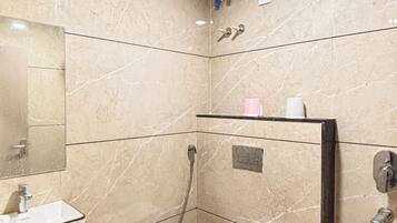 A bathroom with a sink, toilet, shower, and a mirror.