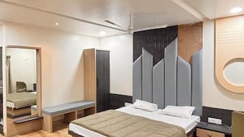 Un dormitorio moderno con una cama grande, una mesita de noche, un armario y un espejo.