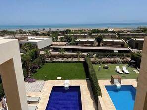 A resort with multiple swimming pools, a well-maintained lawn, and a view of the beach. - Fanadir 3BR • Prime Sea View Villa (Hurghada 2)