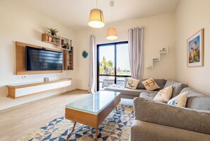 A modern living room with a flat-screen TV, glass coffee table, and a sofa with decorative pillows. - Fanadir 3BR • Prime Sea View Villa (Hurghada 2)