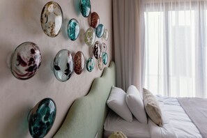 A hotel room with a bed, pillows, and a wall decorated with various glass orbs. - The Reef House Luxury Waterfront Villa (El Gouna Hurghada)