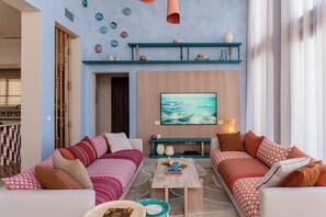 A modern living room with two sofas, a coffee table, and a TV mounted on the wall. - The Reef House Luxury Waterfront Villa (El Gouna Hurghada)