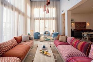 A modern living room with two sofas, a coffee table, and a dining area.