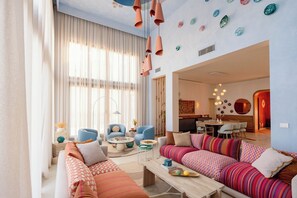 A modern living room with a sofa set, a coffee table, and a dining area with chairs. - The Reef House Luxury Waterfront Villa (El Gouna Hurghada)