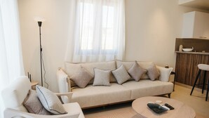 Una sala de estar moderna con un sofá, un sillón y una mesa de centro.