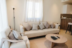 Ein modernes Wohnzimmer mit einer Couch, einem Sessel und einem Couchtisch.