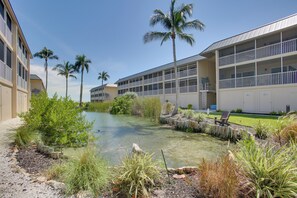 A hotel with a pool area surrounded by palm trees and a variety of plants. - Access to Pool & Sanibel Beach: Resort-Style Condo (Sanibel)