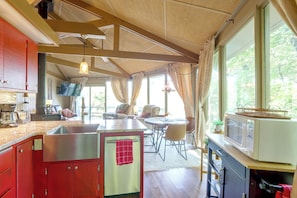 A kitchen with a built-in microwave, a sink, and a dining area with a table and chairs.