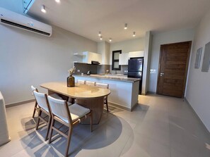 A modern kitchen with a central island, white cabinetry, and a built-in oven. - Bohemian-Style 3BR Townhouse in Shedwan, El Gouna. (Hurghada)