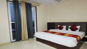 Ein Hotelzimmer mit Bett, Vorhängen, Deckenventilator und Blick durch ein Fenster.