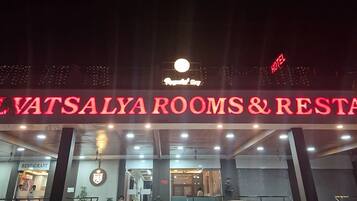 A hotel entrance with a sign for 'Vatsalya Rooms & Restaurant' and a visible 'Hotel' sign.