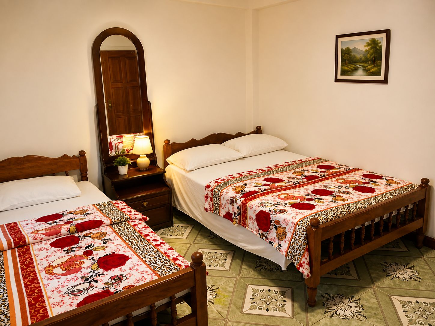 A bedroom with two beds, a nightstand with a lamp, a mirror, and a framed picture on the wall.