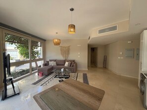 A modern living room with a sofa, coffee table, and pendant lights. - Cozy 1BR GF Mangroovy Residence (Hurghada)
