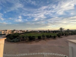 Ein Wohngebiet mit Golfplatz, Palmen und blauem Himmel.