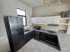 A modern kitchen with a refrigerator, microwave, stove, and oven. - Tawila 3BR Family Townhouse • Lagoon Retreat Villa (Hurghada 2)
