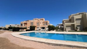 Un complesso residenziale con piscina, diversi edifici e cielo sereno.