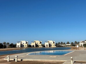 A swimming pool area with modern buildings in the background.
