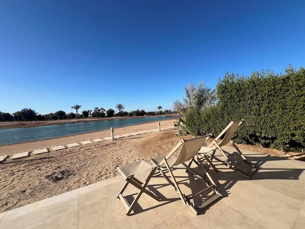 A beachside area with lounge chairs and a clear view of the water.