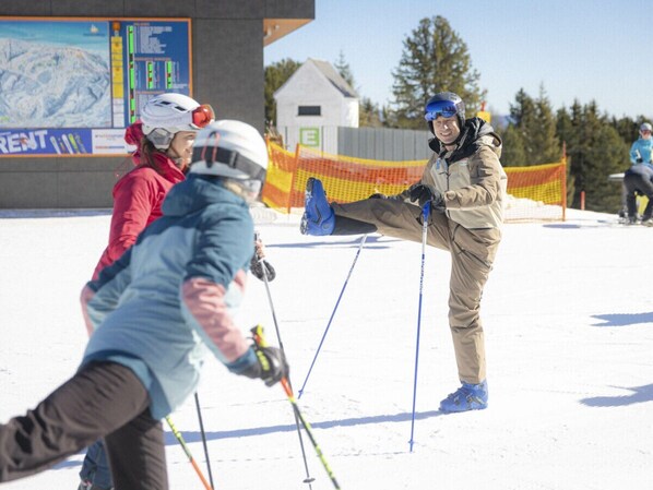A ski slope with skiers and a ski instructor. - One-bedroom Cabin (Sankt Georgen am Kreischberg)