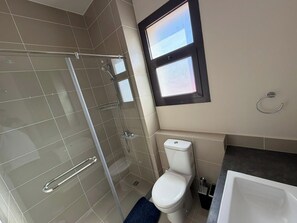 A bathroom with a glass-enclosed shower, a toilet, and a bathtub. - Cyan Elegant 3BR Golf View Escape (Hurghada)