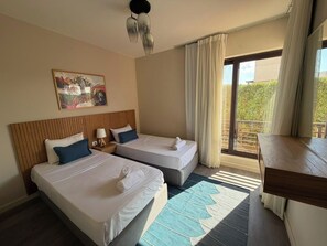 A hotel room with two beds, a wooden headboard, a painting on the wall, a window with curtains, and a view of greenery outside. - Cyan Elegant 3BR Golf View Escape (Hurghada)